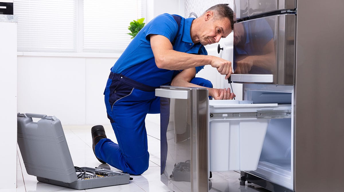 Dor-Mar Appliance repair man working on refrigerator